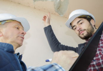 Two contractors looking at construction defects