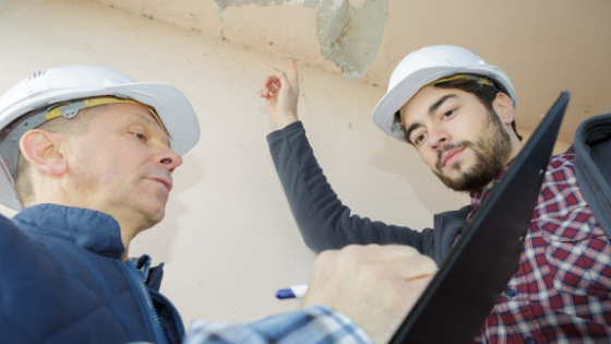 Two contractors looking at construction defects