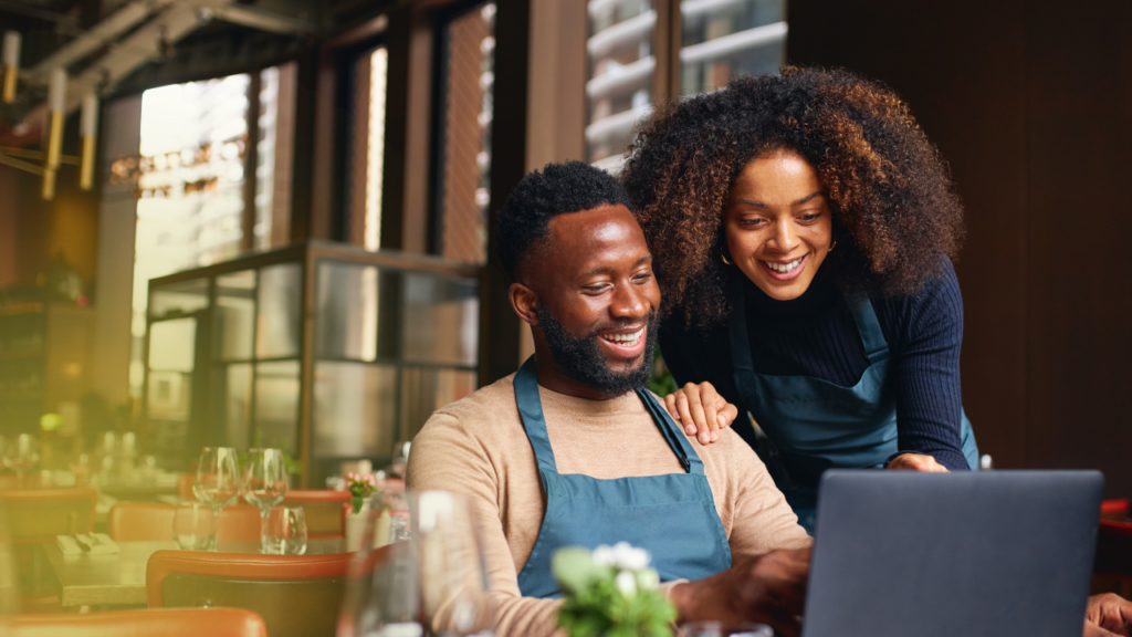 two-business-owners-looking-over-shoulder-and-looking-at-computer