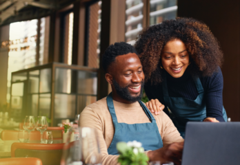 two-business-owners-looking-over-shoulder-and-looking-at-computer
